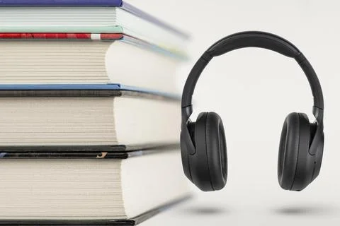 Audiobooks. Audiobook concept, stack of books and headphones with space for copy Stock Photos