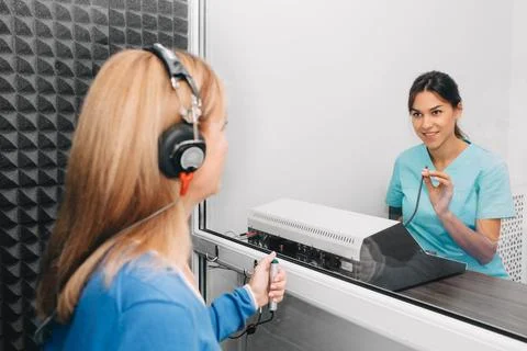 Audiologist doing hearing test in special audio room Fotos de archivo