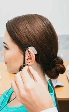 Audiologist programming hearing aid acoustic response using the software. You 스톡 사진