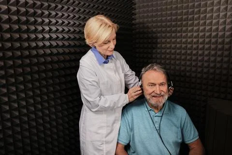 Audiometry. Audiologist doing hearing exam to a elderly man in soundproof aud Foto stock