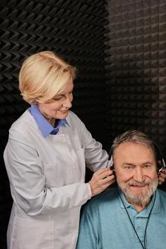 Audiometry, pure tone audiogram test. Audiologist doing hearing exam to mat.. Fotos Stock