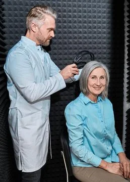 Audiometry, pure tone audiogram test. Audiologist doing hearing exam to matur Foto stock
