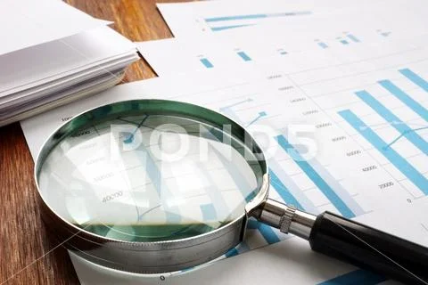 Audit and accounting concept. Magnifier and business papers. Stock Photos