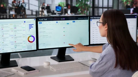 Auditor Reviews Compliance Logs On Multiple Screens Stock Footage 333842402