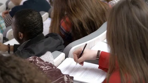 Auditorium full of intelligent multi-ethnic students participating in lecture Stock Footage 69929622