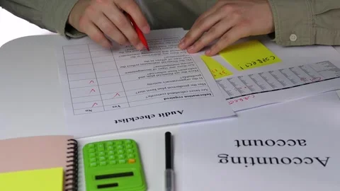 An auditors hands use a red marker to check yes or no boxes on a verification 스톡 동영상 316584877
