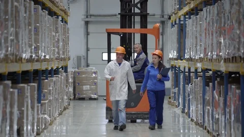 Auditors Wearing Hard Hat Counts Merchandise in Warehouse. Walks Through Rows of Stock Footage 106194642