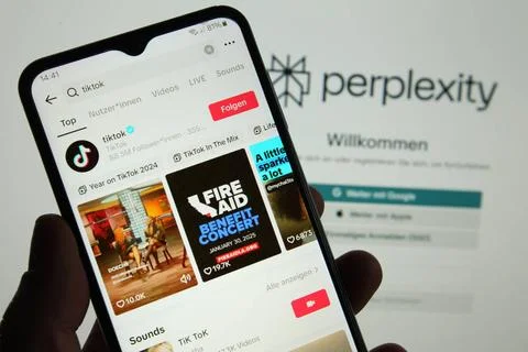  Auf einem Smartphone wurde das Videoportal TikTok aufgerufen. Dahinter wu... Stock Photos