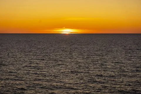 Auf hoher See: Erlebnis Sonnenuntergang. Langsam versinkt die Sonne hinter... Stock Photos