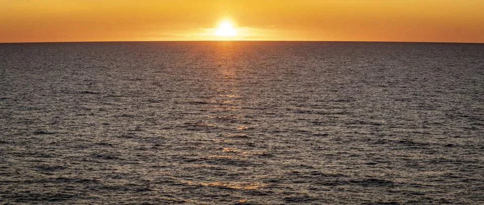 Auf hoher See: Erlebnis Sonnenuntergang. Langsam versinkt die Sonne hinter... Stock Photos