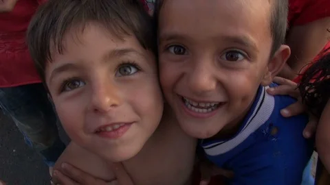 August 2016: Barefooted Syrian dispalced kids laugh to camera in Aleppo, Syria Vídeos de archivo 119988531