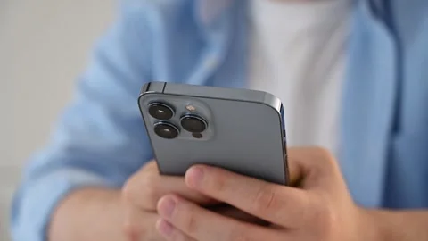 August 24, 2023 Vilnius,Lithuania. 4k. man using iPhone 13 max smartphone Stock Footage 250433664