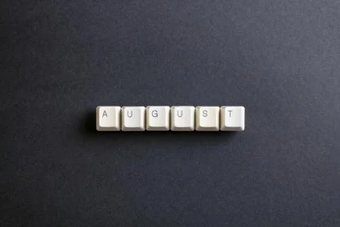 August month word is written with computer keys button on a dark background. Foto stock