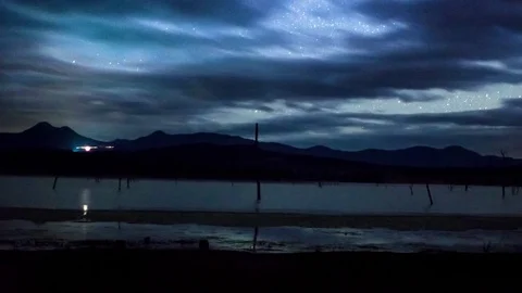 Aurora Borealis and clouds moving over Wanaka lake at night Stock Footage 76103553