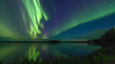Aurora Borealis outburst over reflective Alaskan Lake Stock Footage