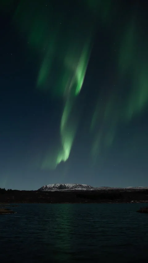 Aurora borealis over mountain and Thingvellir lake Iceland vertical format Stock Footage 326793539