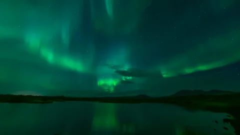 Aurora borealis reflecting in calm lake water Thingvellir Iceland Stock Footage