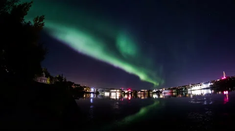 Aurora borealis Reykjavik city lights houses trees water reflection realistic 4k Stock Footage