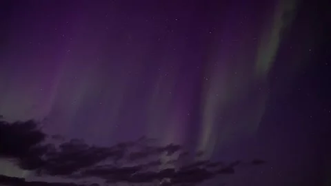 Aurora borealis sprites behind clouds on stars Stock Footage 240550241