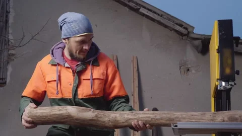 An Australian Aboriginal wind instrument maker saws a machined log into halves Stock Footage 244991669