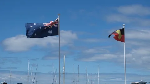 Australian and Aboriginal Flags Flying Together in Australia sky Stock Footage 291591012