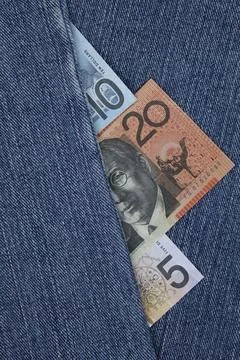 Australian banknotes of different denomination between blue denim fabric Stock Photos