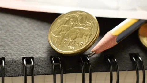 Australian dollar over a notebook with spiral and pencil Stock Footage