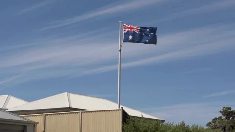 Australian flag on a pole in the wind in Australian suburb 스톡 동영상 131279331