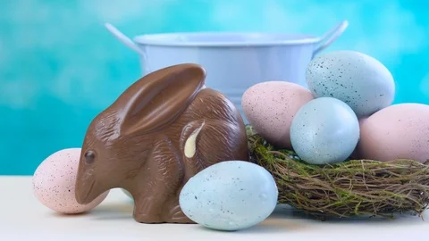 Australian milk chocolate Bilby Easter egg with eggs in nest against a blue a Stock Footage 86663670