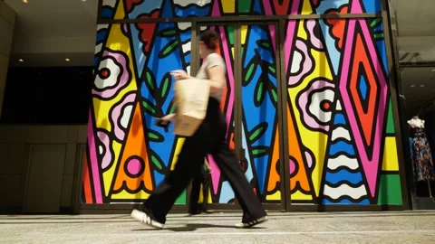 Australian pedestrians pass a colourful pattern design in Brisbane 6K Stock Footage 329080244