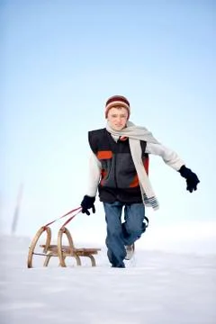 Austria, boy (12-13) pulling sledge in snow Foto stock