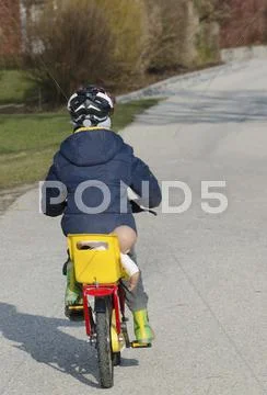Austria, Boy cycling with doll on seat Stock Photos