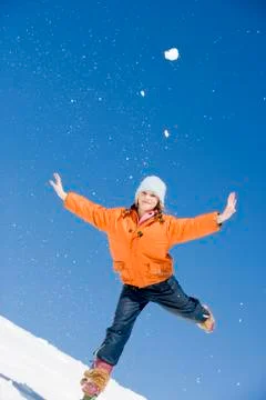 Austria, girl (12-13) in snow balancing on one leg with arms outstretched, Stock Photos