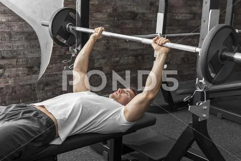 Austria, Klagenfurt, Man in fitness center doing weight lifting Stock Photos