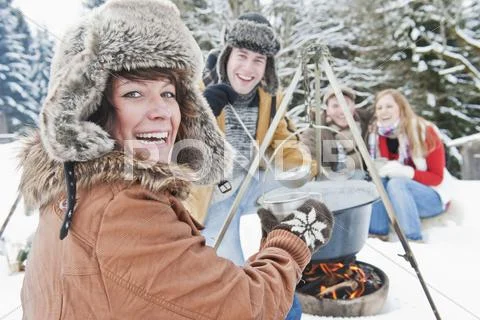 Austria, Salzburg Country, Flachau, Young men and women sitting near fireplace Stock Photos