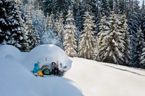 Austria, Salzburg County, Family sitting near igloo Stock Photos
