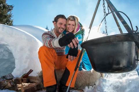 Austria, Salzburg, Couple preparing tea near igloo, smiling Stock Photos
