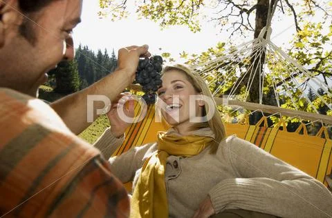 Austria, Salzburger Land, Altenmarkt, Couple lying in hammock, smiling, portrait Stock Photos