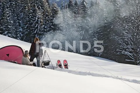 Austria, Salzburger Land, Couple in front of tent, cooking on campfire Stock Photos