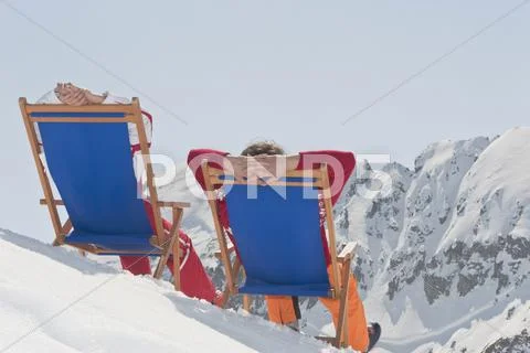 Austria, Salzburger Land, Couple sitting in deck chairs, rear view Stock Photos