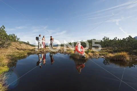 Austria, Salzburger Land, Four hikers near lake Stock Photos