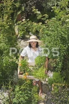 Austria, Salzburger Land, Woman carrying wooden box with plants Stock Photos