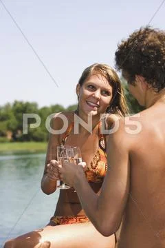 Austria, Salzkammergut, Lake Mondsee, Young couple clinking glasses Stock Photos