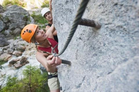 Austria, Steiermark, Ramsau, Silberkarklamm, Young couple climbing rock, looking Stock Photos