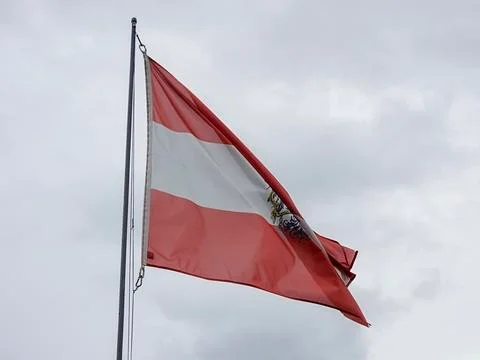 Austrian flag waving over cloudy sky Stock Photos