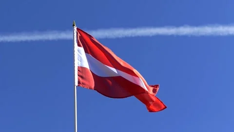 The Austrian flag waving in the wind in the blue sky Stock Footage 282432737