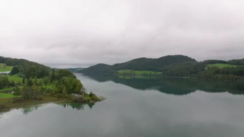 Austrian Lake Surrounded by Lush Green Forests and Misty Mountain Ranges 库存影片 330954939