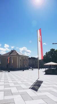 Austrian triangle flag Waving on a pole over beautiful sky Stock Photos