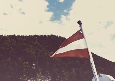Austrian triangle flag Waving on a pole over beautiful sky Stock Photos