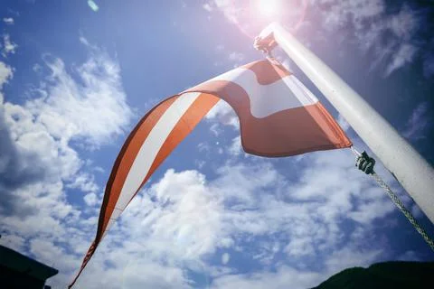 Austrian triangle flag Waving on a pole over beautiful sky Stock Photos
